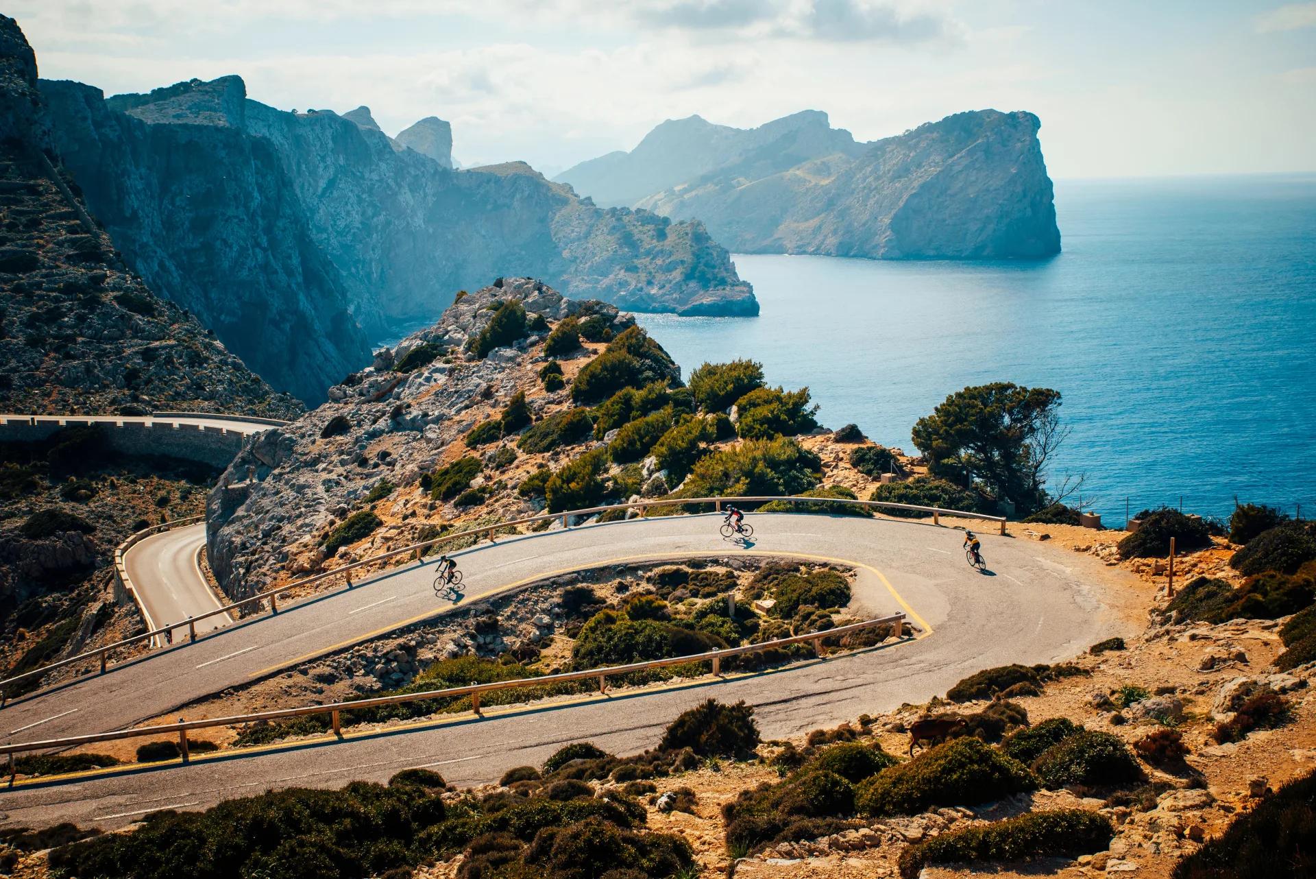 Cyclists descending a hairpin bend on the coastal cliffs of Mallorca